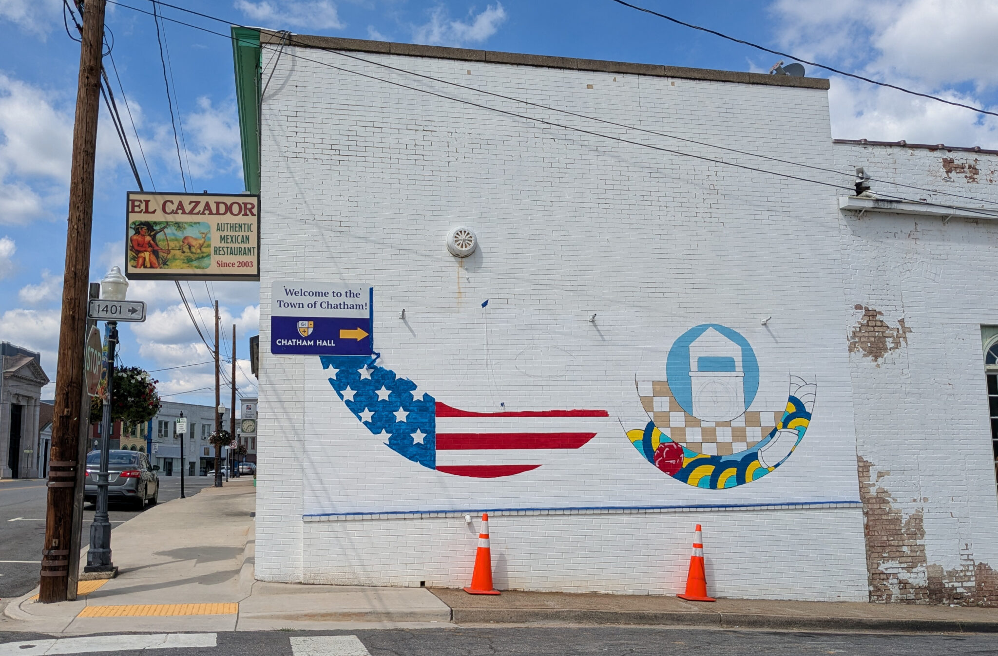 A partially painted mural on the south wall of El Cazador, featuring the American flag and abstract shapes.